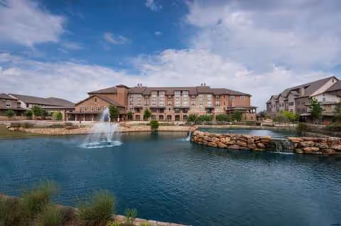 Exterior view of Watermere at Southlake with fountain pond and surrounding buildings.