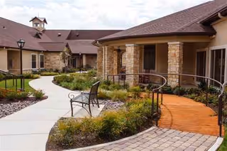 Outdoor courtyard at Bel Air at Teravista featuring winding walkway, benches, and landscaped garden.