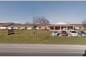 Single-story care center with a parking lot and grassy front yard