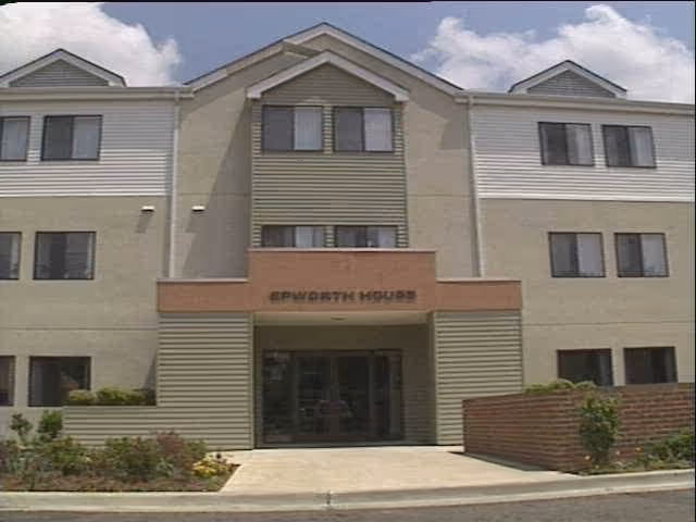 Front exterior view of a three-story building named Epworth House with multiple windows, a central entrance, and landscaping in front.