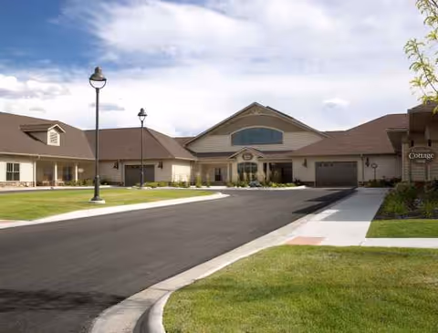 Exterior view of The Grandview at Benefis with driveway, lamps, and manicured lawn.