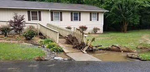 Exterior view of Riverside Village Homes Unit I with damaged landscaping and a ramp.
