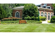 The Richland Place building exterior features brick walls, arched windows, and a manicured lawn.