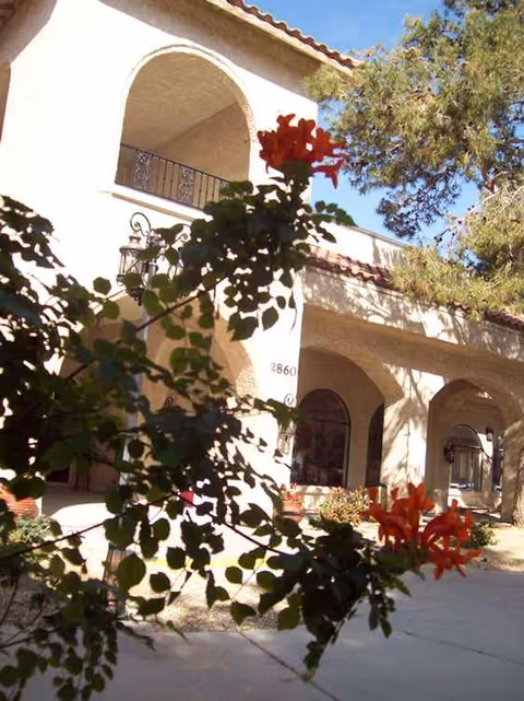Exterior view of Mission Pines Nursing & Rehabilitation Center with arches and greenery.