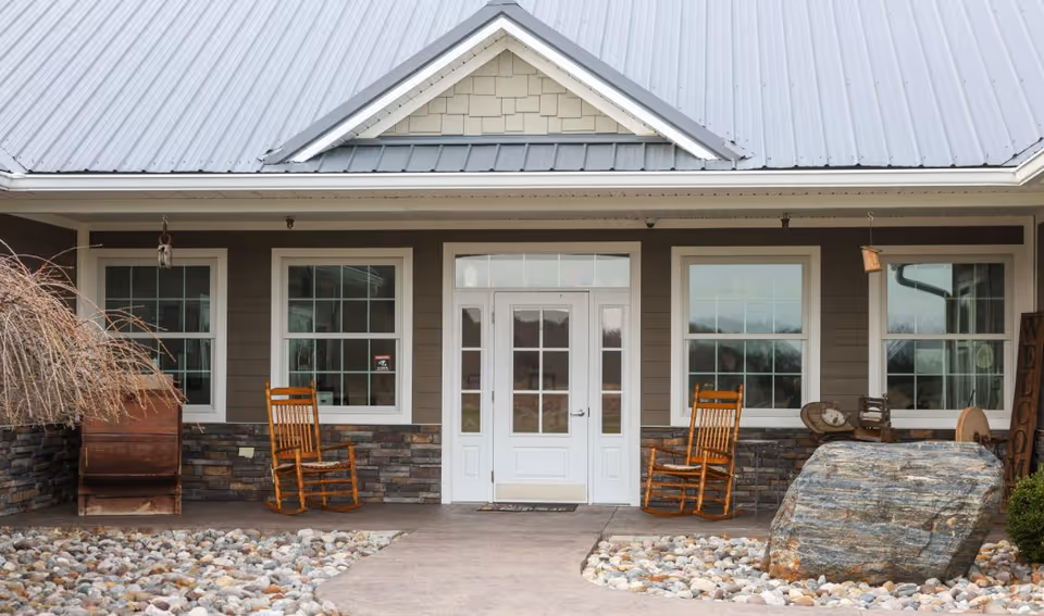 Front entrance of Elder Ridge Manor II with rocking chairs on a stone porch.