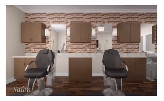 Interior view of a salon area with two black salon chairs in front of a counter with mirrors mounted on a brick accent wall. There are brown cabinets above and below the counter, and the floor is dark wood.