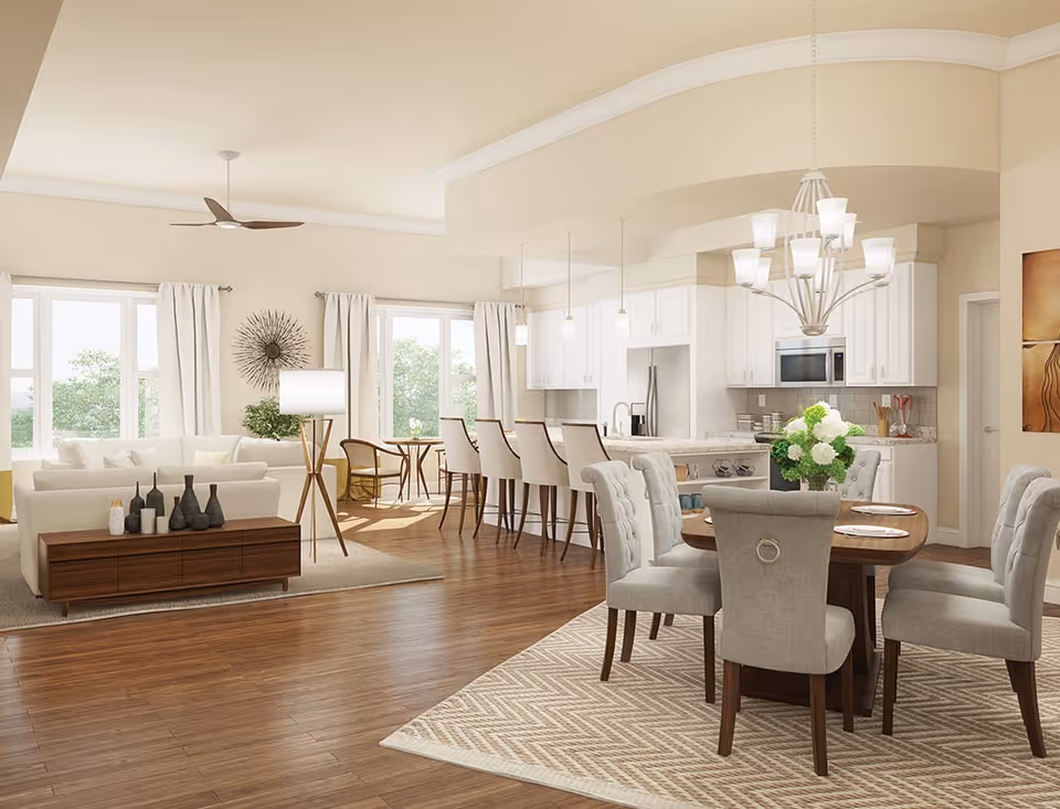 Bright open-plan interior showing a living area with sofas, a dining table, and a white kitchen with an island and bar stools.
