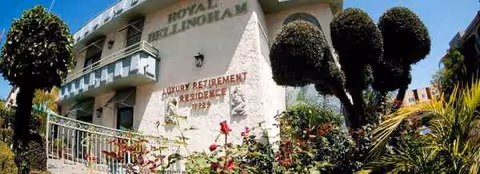 Exterior of Royal Bellingham Luxury Retirement Residence with balconies and lush landscaping.