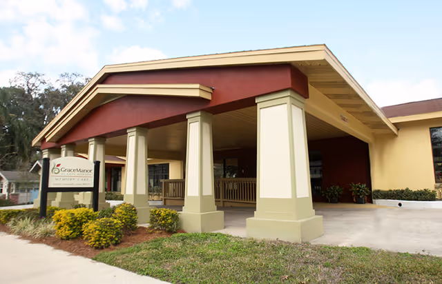 Front entrance of Grace Manor at Lake Morton showing a covered portico with columns and an on-site sign.