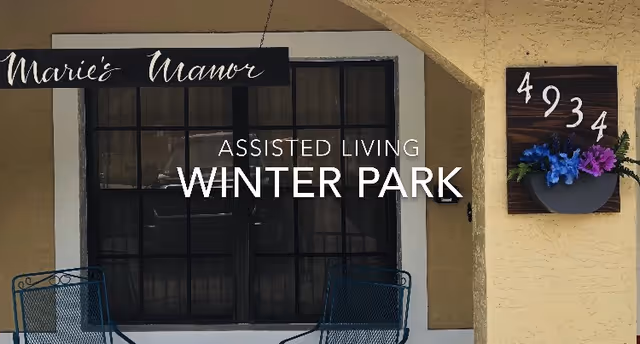 Front entrance of Marie's Manor Assisted Living showing a window with two chairs, signage, and an address plaque reading 4934.