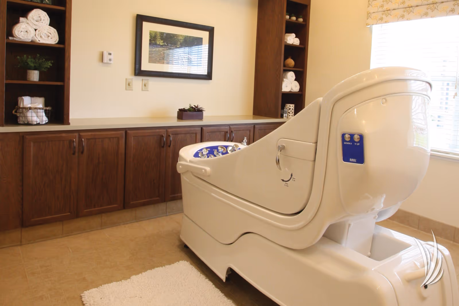 Bright bathing room with a white walk-in spa tub, wood cabinetry and open shelves stocked with towels.