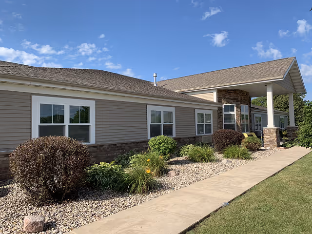 Front-facing, single-story assisted living building with a walkway and covered entrance.