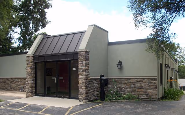 Exterior view of Gate House entrance with stone facade and glass doors.