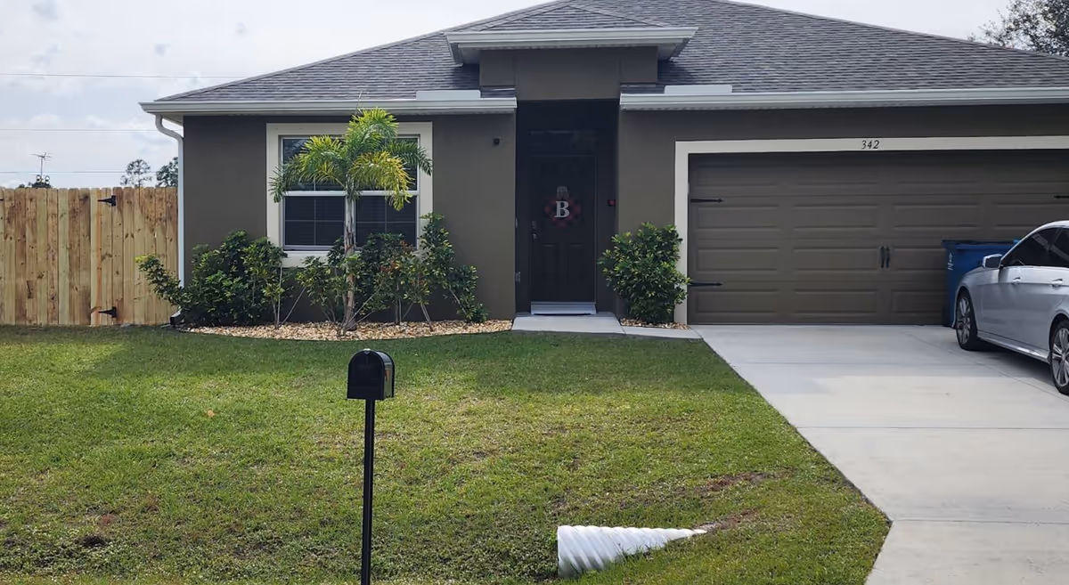 Front exterior of a single-story home with a two-car garage and manicured lawn.