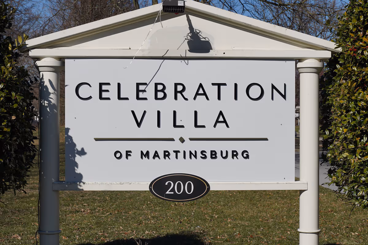 Outdoor sign for Celebration Villa of Martinsburg with the number 200 displayed below the name, surrounded by greenery and trees in the background.