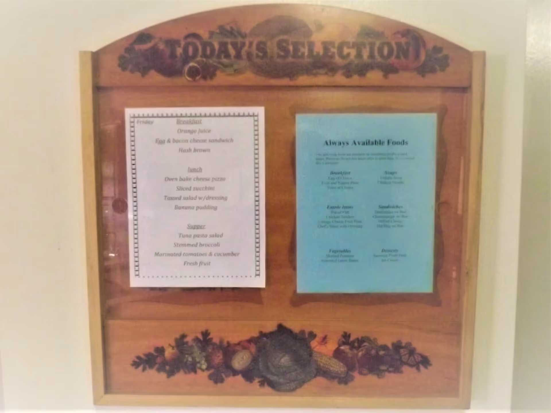 Wooden menu board titled "Today's Selection" mounted on a wall with two printed menu sheets.