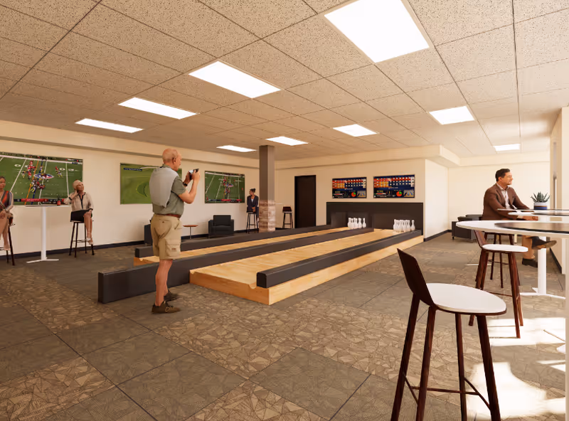 A spacious indoor recreational lounge with bocce-style bowling lanes, high tables and stools, TVs on the walls, and people socializing.