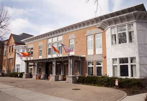 Wickshire Wilmette senior living facility exterior with flags and a covered entrance.