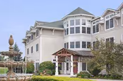 Exterior view of Partridge House senior living facility entrance with fountain and landscaping.