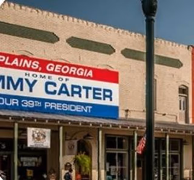 Brick storefront along a street with a large blue and white sign.