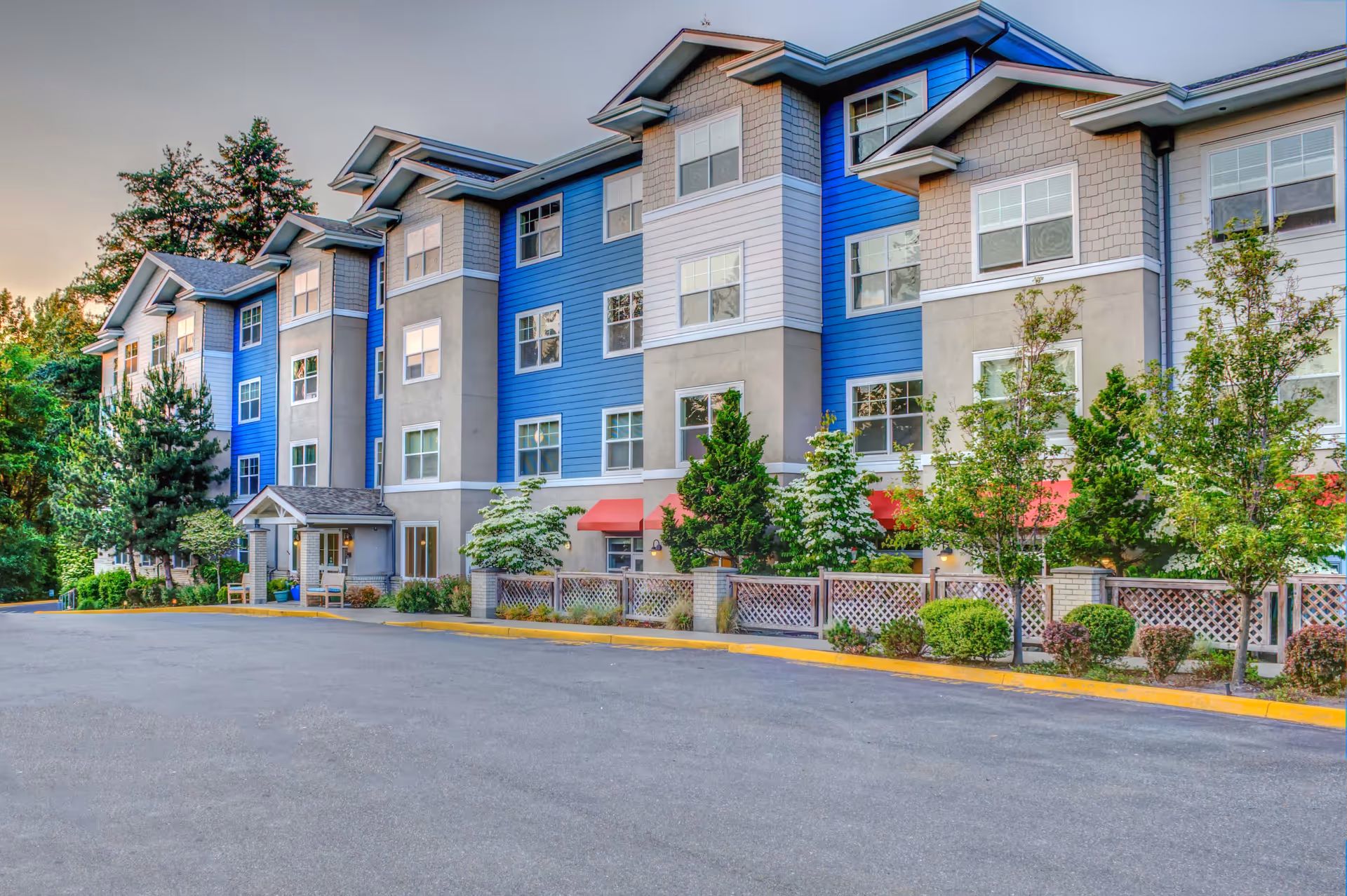 Exterior view of The Creekside senior living building with blue siding and a parking lot.