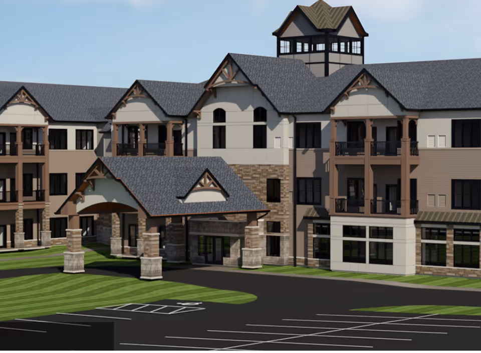 Exterior view of a multi-story senior living facility building with a covered entrance, balconies, large windows, and a parking lot in front.