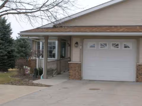 Front exterior of a single-story senior living home with a covered entry and garage.