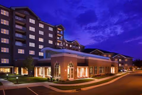 Exterior view of Southminster senior living facility at dusk, brick building with illuminated entrances.