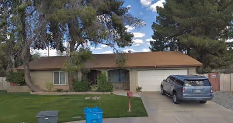 Front view of a single-story brick facility with driveway and a parked SUV.