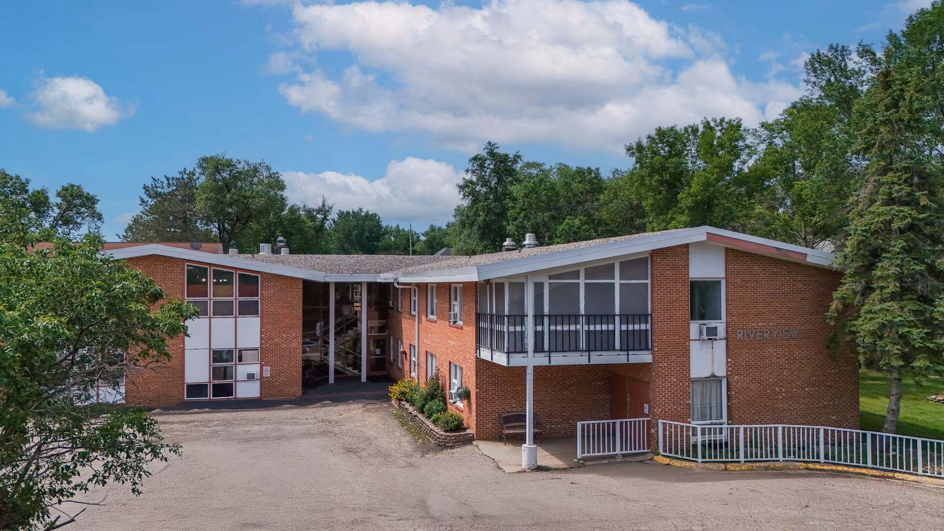 Exterior view of Riverview Healthcare facility surrounded by trees.