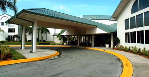 Exterior view of Discovery Village Vero Beach entrance with a porte-cochère and curved driveway.
