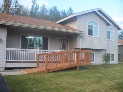 Exterior of a two-story home with a wooden ramp to the front door.