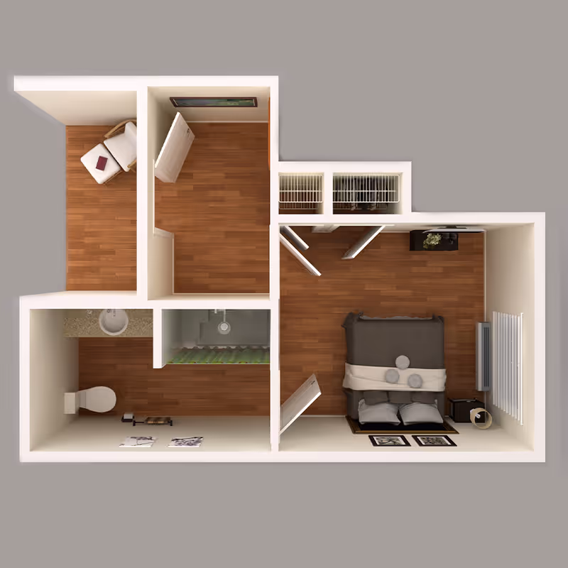 3D floor plan of an assisted living apartment featuring a bedroom with a bed, nightstand, and window, a bathroom with a toilet, sink, and shower, and a small living area with a chair and ottoman. The apartment has wood flooring throughout and closets near the bedroom.