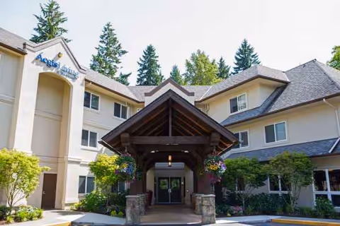 Exterior view of Aegis Living Marymoor entrance with covered walkway and surrounding greenery.