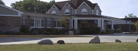 Exterior view of The Lodge at Taylor with a covered entrance and manicured landscaping.