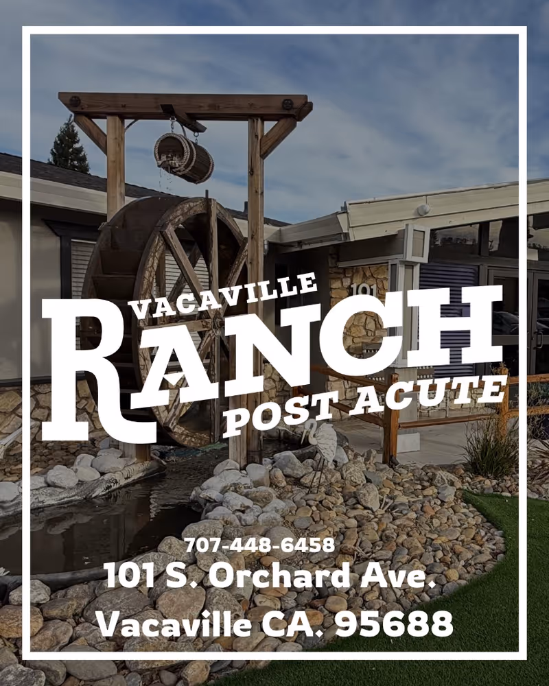 Exterior entrance of Vacaville Ranch Post Acute with a decorative water wheel, rock landscaping, and building façade overlaid with the facility name and address.