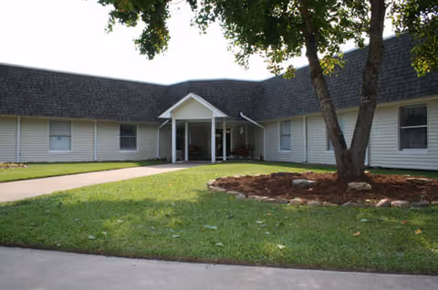 Front exterior of Corrigan LTC Nursing and Rehab building with entrance and green lawn