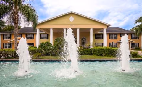 Front view of Grand Villa of Delray Beach East exterior with columns and fountain.