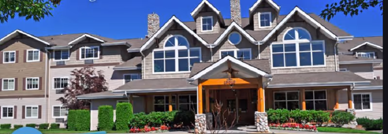 Front exterior of Vineyard Park of Sumner, a large senior living facility with landscaped entrance.
