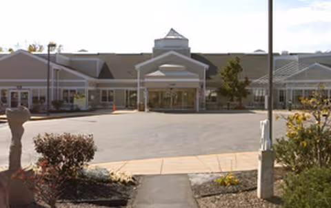 Exterior view of a senior living facility entrance with a covered drop-off area.