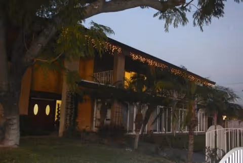Exterior view of New Horizon Senior Living building with string lights at dusk.