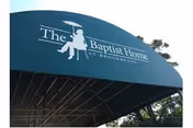 Blue curved canopy with The Baptist Home at Brookmeade signage over entrance.