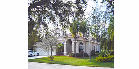 Front view of a single-story senior living building with a manicured lawn.