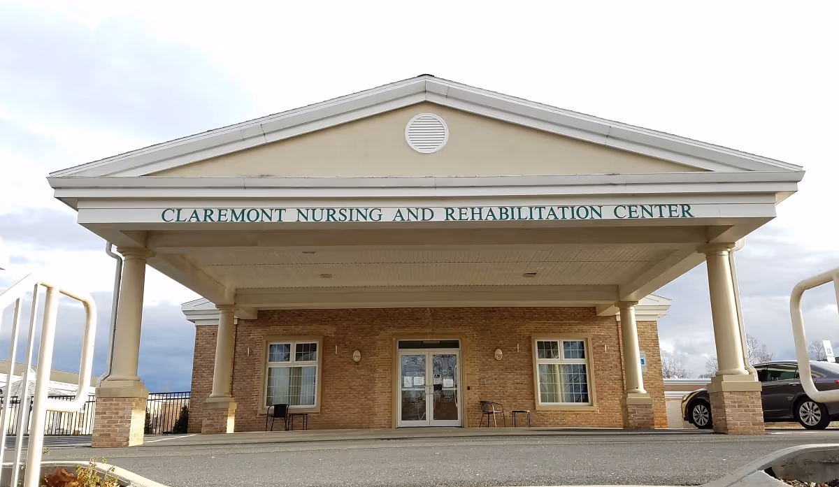 Front entrance of a nursing and rehabilitation center with a large covered portico supported by columns.