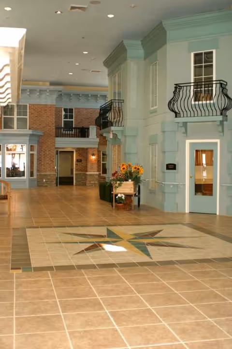 Light-filled lobby with teal walls, balconies, and a star-pattern tiled floor.