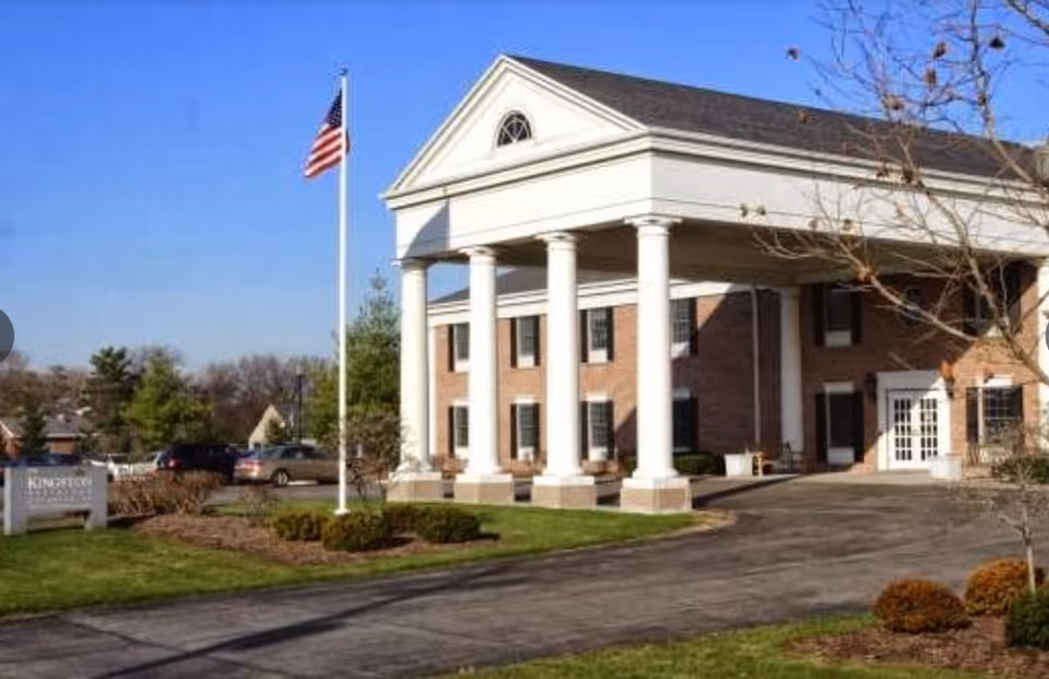 Exterior view of Kingston Residence of Perrysburg featuring a brick building and columns.