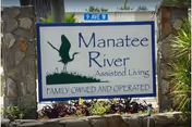 Outdoor sign reading 'Manatee River Assisted Living' with a bird logo and 'Family Owned and Operated' below.