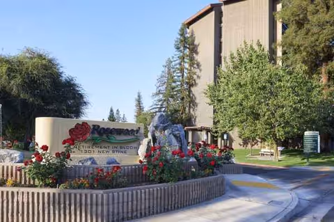 Exterior view of Health Center at Rosewood with landscaped entrance sign and greenery.
