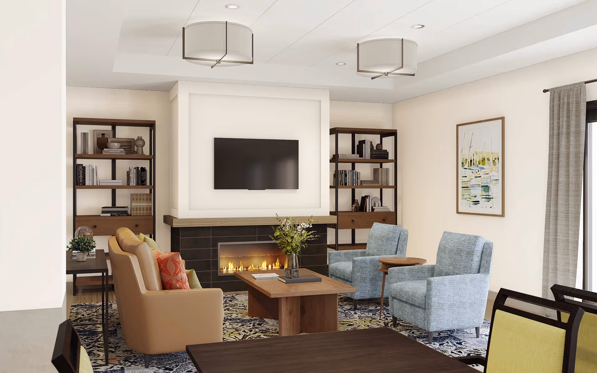 A cozy senior living room with a modern fireplace beneath a wall-mounted flat-screen TV. The room features a beige sofa with colorful pillows, two light blue armchairs, a wooden coffee table with a vase of flowers, two bookshelves filled with books and decor, a patterned rug, and a framed painting on the wall. Large windows with curtains allow natural light to brighten the space.