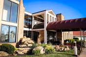 Exterior view of Villa St. Francis Catholic Care Center entrance with rock garden and awning.